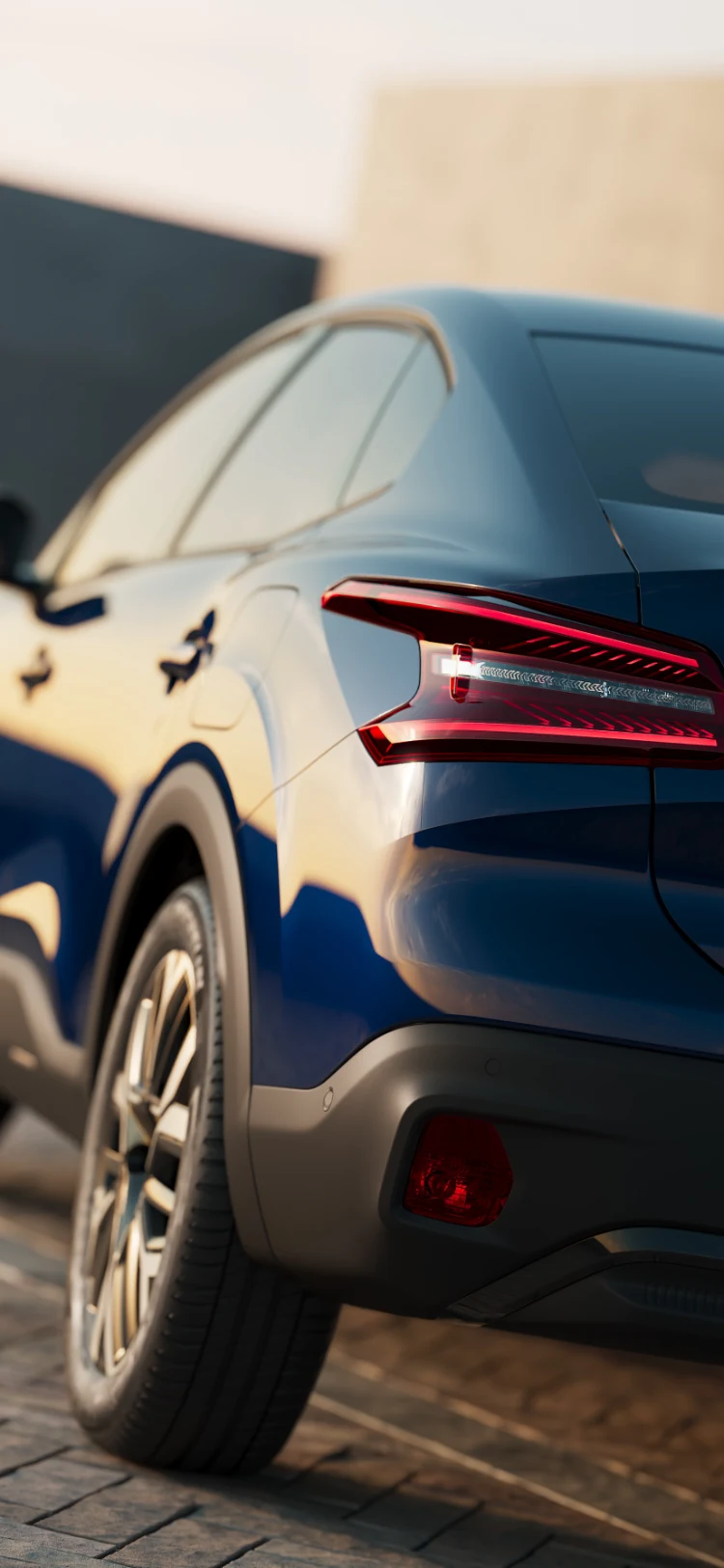 Primo piano della Citroën ë-C4 X con il design del fanale posteriore illuminato dalla calda luce del tramonto